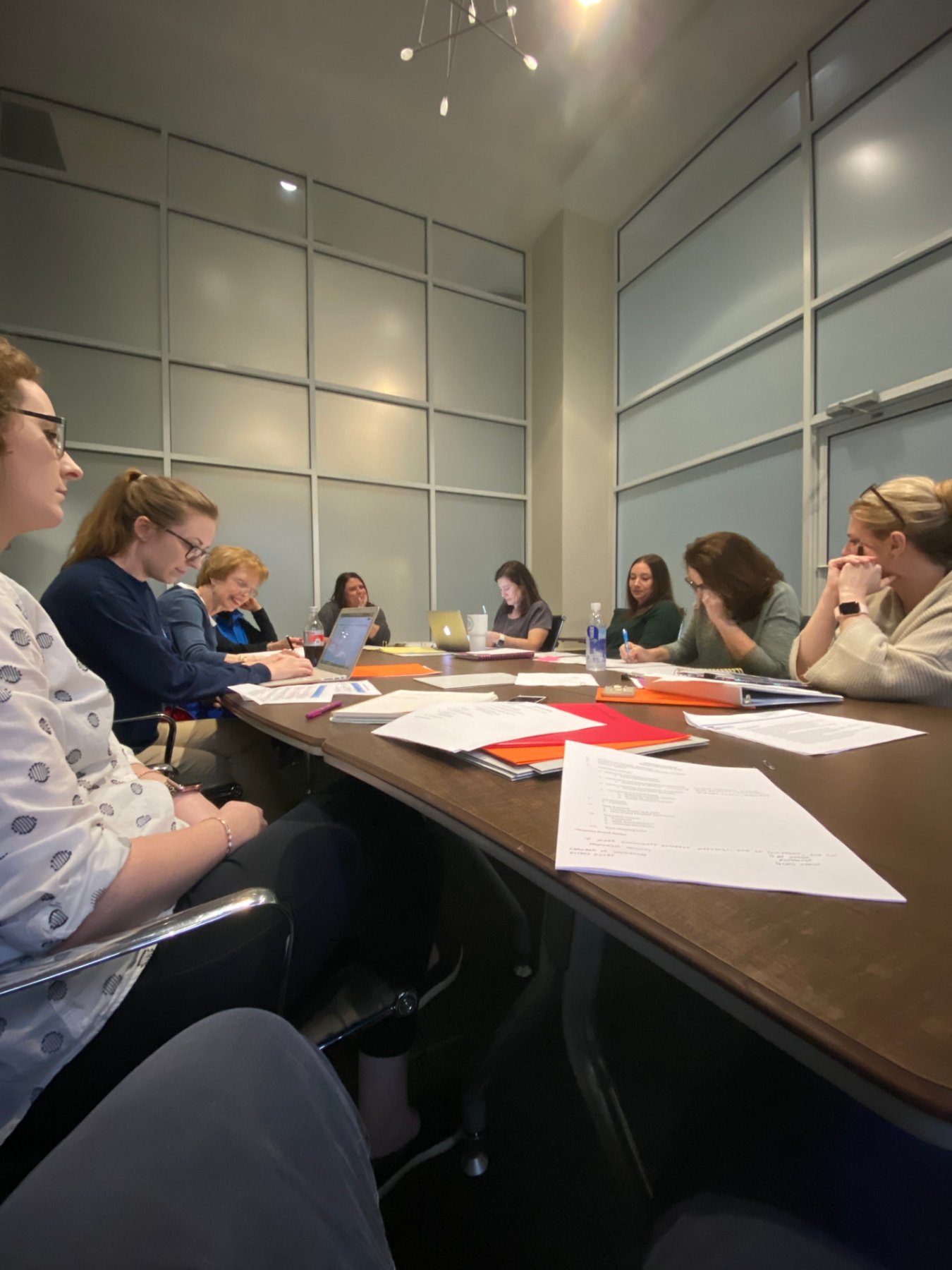 An early Lighthouse leadership planning meeting in 2020, with papers, binders and laptops spread across a conference table