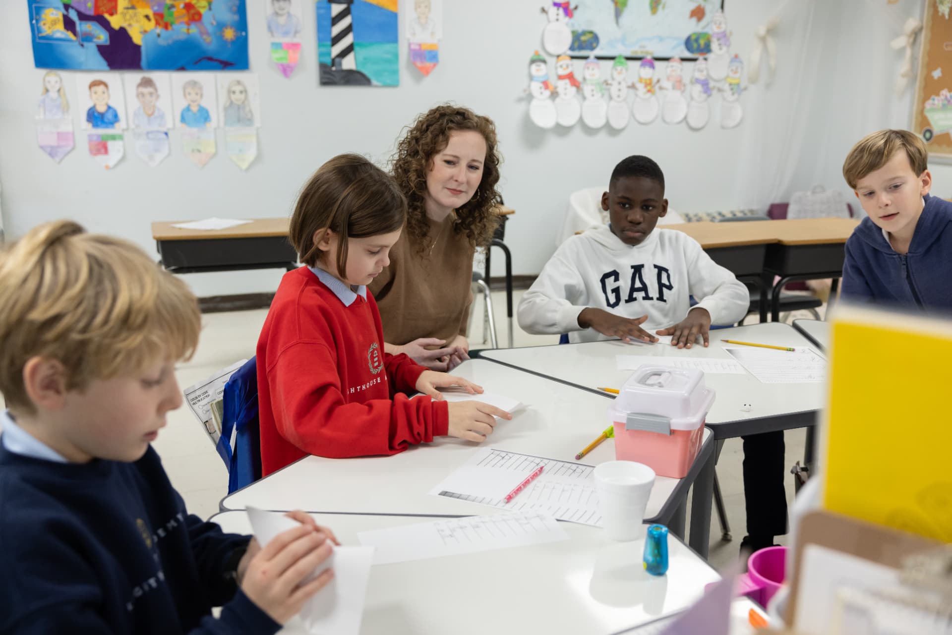 A teacher guiding a small group of students through a writing activity